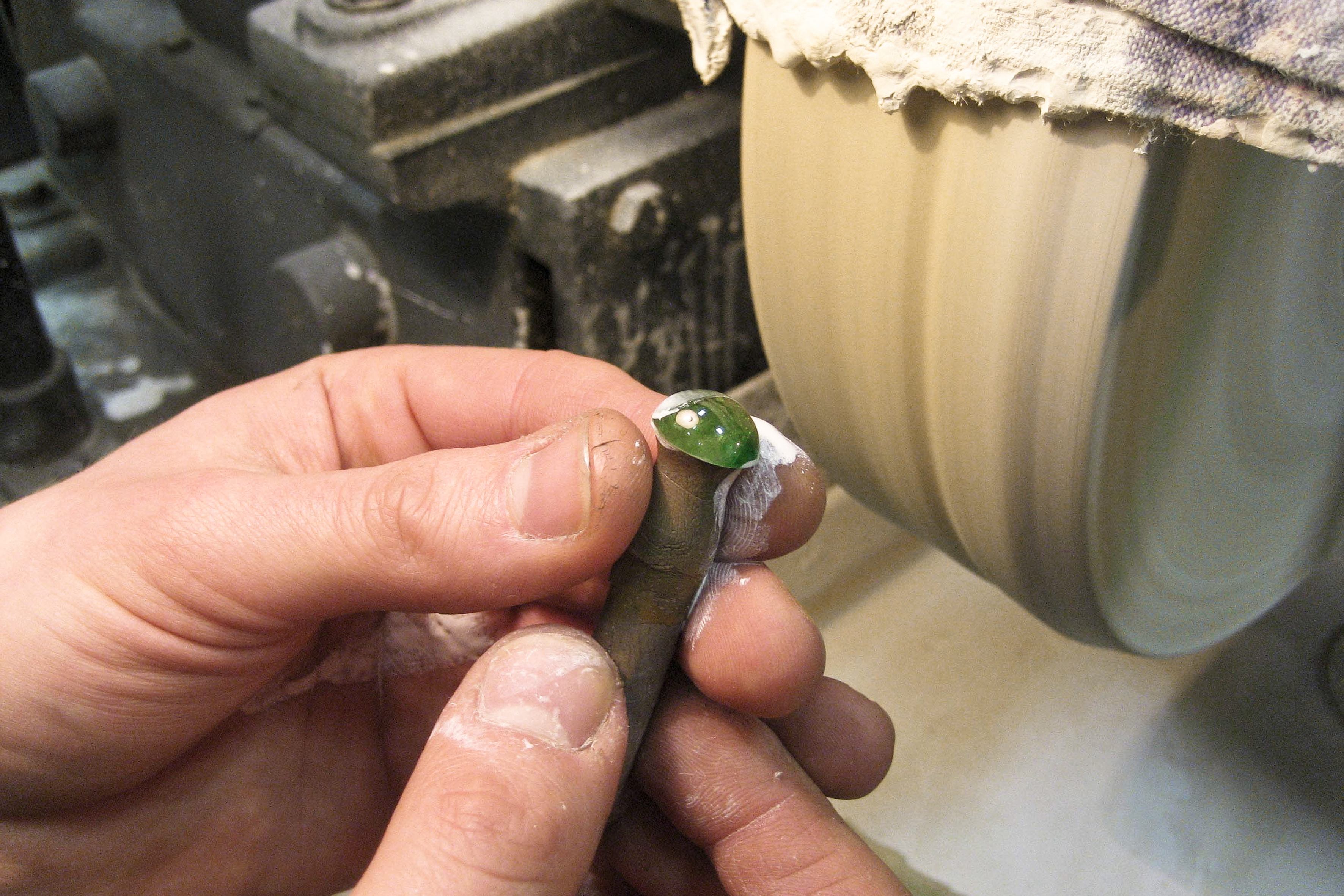 polishing a garnet cabochon on the polishing felt-wheel